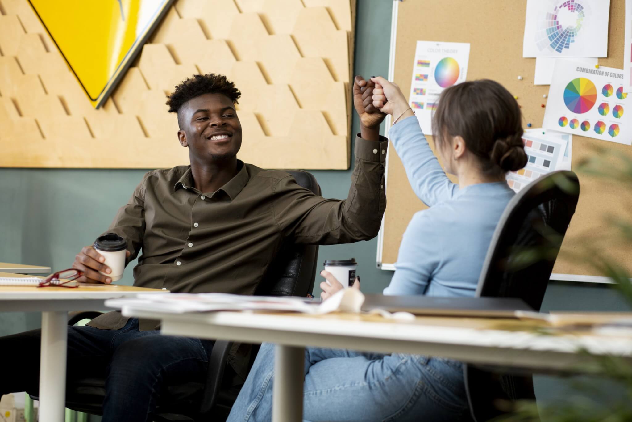 medium-shot-smiley-colleagues-fist-bump-scaled